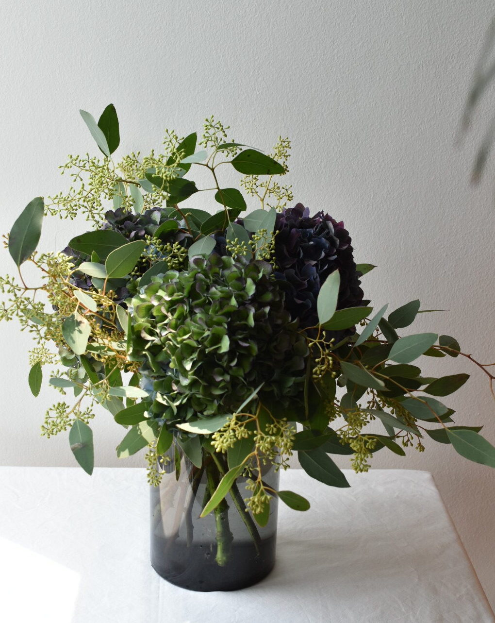 Corporate floral arrangement with seasonal greenery by WOOLLAHRA STUDIO in Singapore.